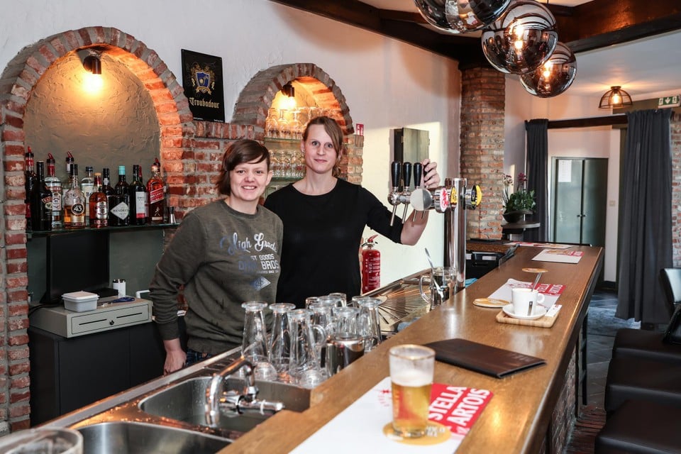 Cindy de Moor en Wenke De Herdt achter de tap van ’t Heuvelzicht dat anderhalf jaar gesloten bleef.