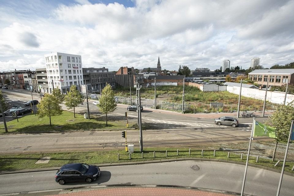 Links over het kruispunt Zwaantjes op de foto ziet u de witte blok met kinderdagverblijf en appartementen die al gebouwd is. Rechts ervan de leegte, waar de rest van het project moet komen.