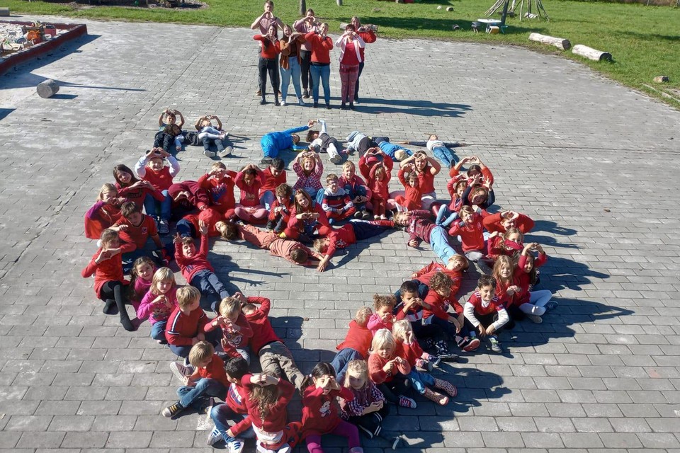 Op de speelplaats vormden de leerlingen samen een hart. 