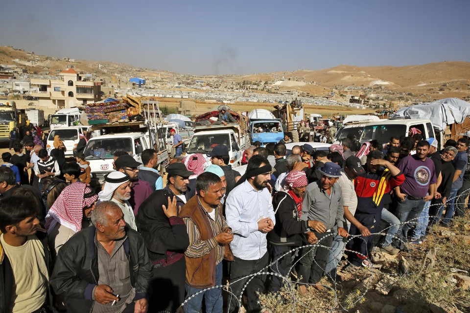 Archiefbeeld: Syrische vluchtelingen wachten net over de grens met Libanon om hun land opnieuw binnen te komen. 