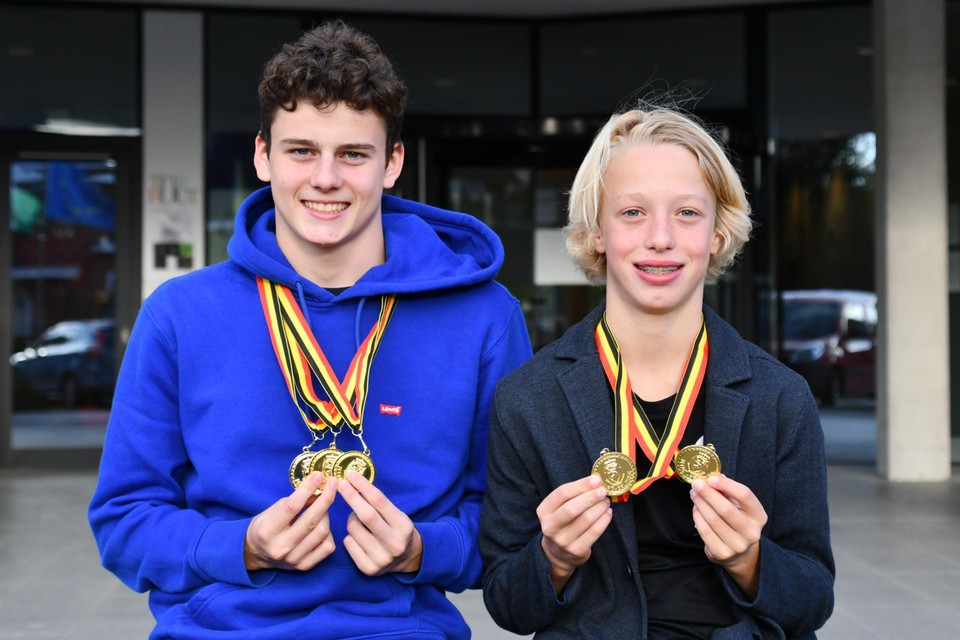 Levi Kindt en Jerome Vandekerkhove tonen hun gouden medailles. 