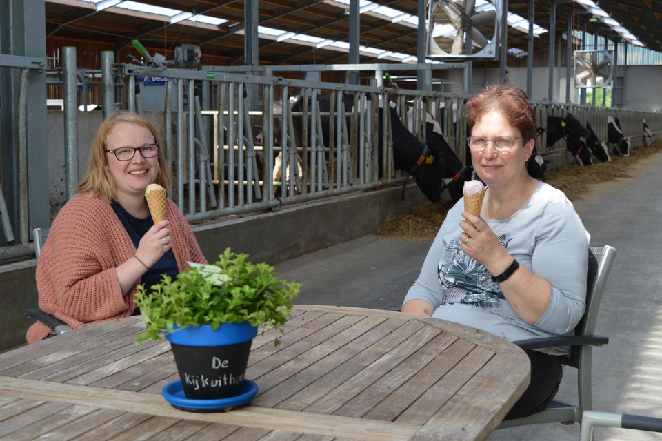 Dochter Delphine en Lucrèce genieten van een ijsje in de koeienstal.
