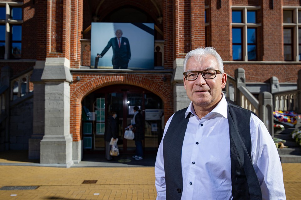 Boven de ingang van het gemeentehuis hangt een grote foto met rouwband van de overleden burgemeester. 