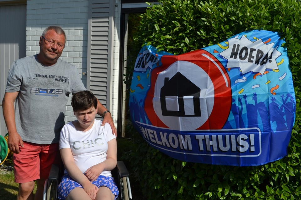Papa Wim en dochter Laura: na 77 dagen opnieuw thuis verenigd. De buren heetten haar welkom met een spandoek.
