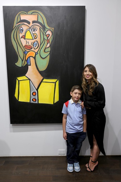 Andres en zijn moeder bij een van de schilderijen. 