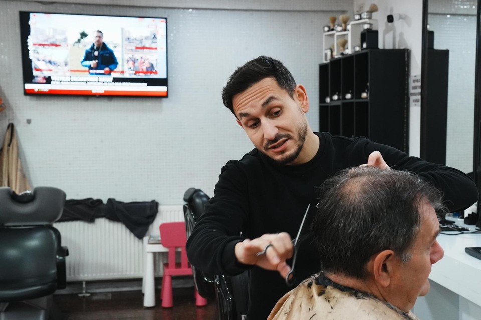 In de kapperszaak van Emre in de Sleepstraat staat de televisie continu aan.