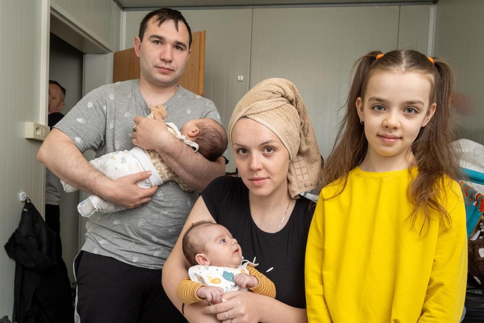 Oleksandr en Kateryna, met haar dochter Anastasiia en hun tweeling Dominik en Damir, in hun krappe kamertje.