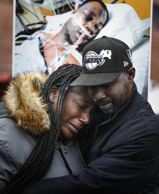 De zus van slachtoffer Tyre Nichols tijdens een betoging op 16 januari, bij een foto van haar broer op zijn ziekenhuisbed.