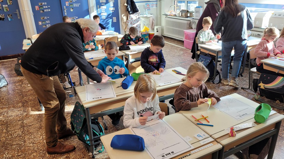 Leo Meeussen toont een leerling hoe hij een visje moet plooien.