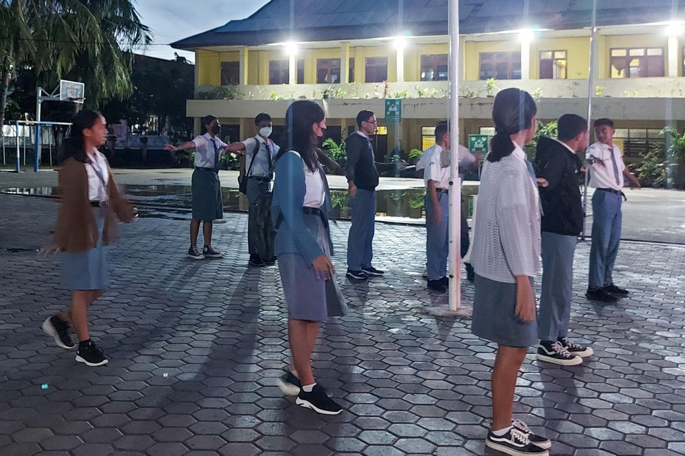Indonesische leerlingen verzamelen zich vroeg in de ochtend op de speelplaats.