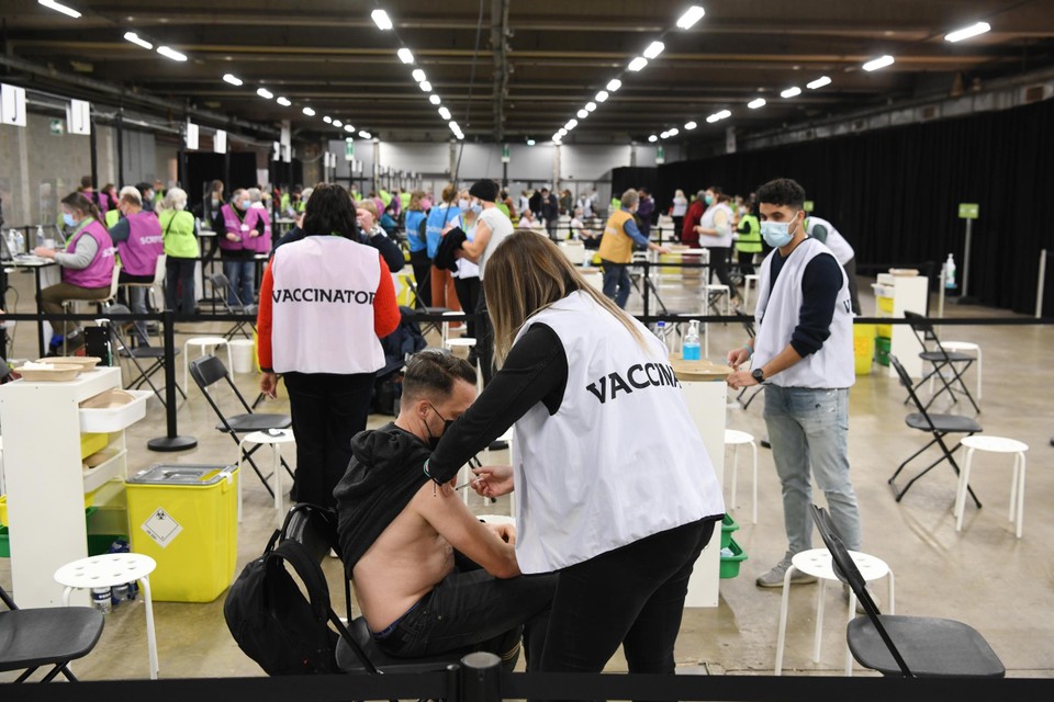 Een medewerkster dient een boosterprik toe in het vaccinatiecentrum in Antwerp Expo.